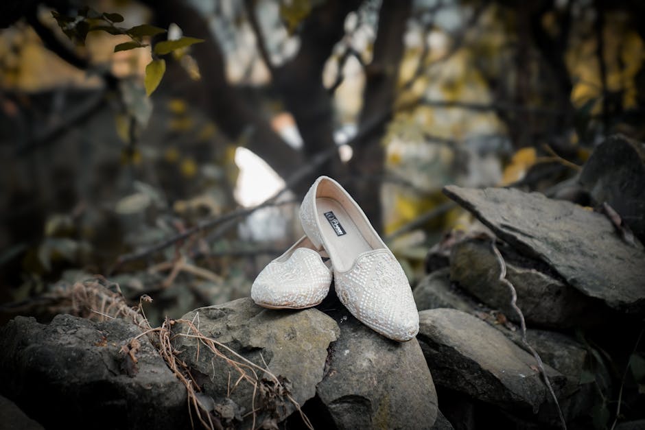 Stylish white shoes elegantly placed on natural stone in an outdoor setting.