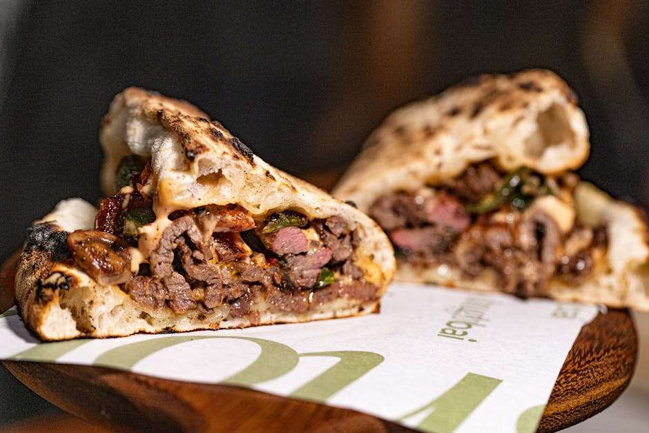 Gourmet grilled meat sandwich with melted cheese and vegetables.