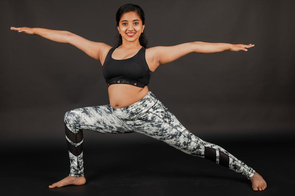 Young woman practicing yoga in a studio, wearing athletic gear.