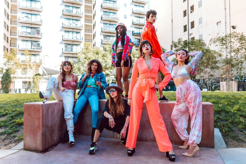 A fashion-forward diverse group showcasing vibrant street style in a city backdrop.