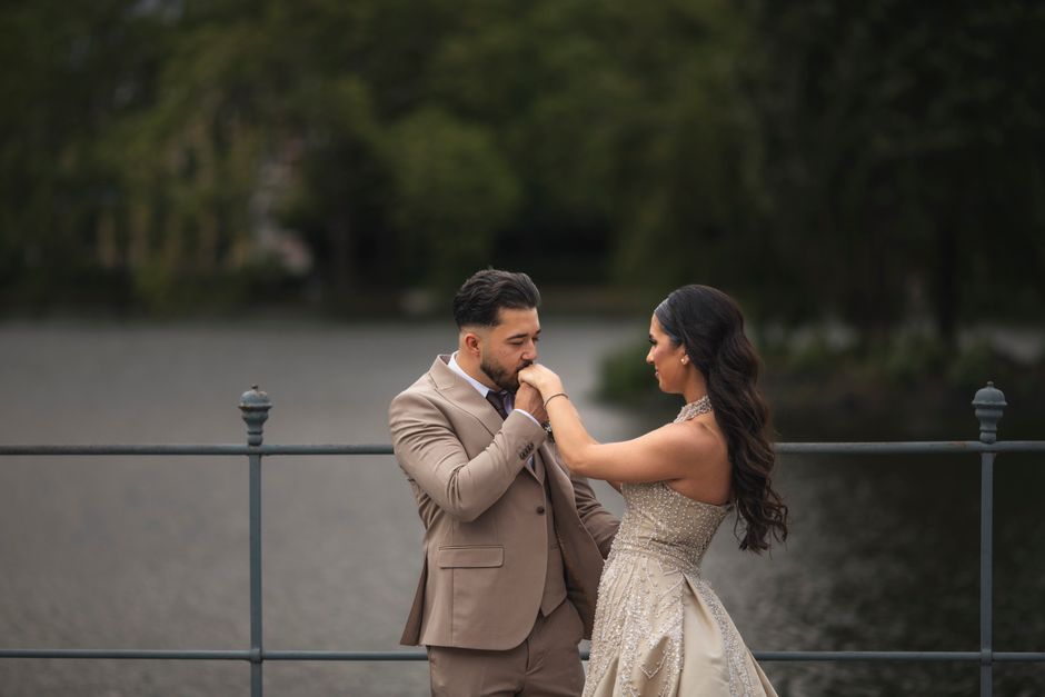 Elegant couple shares a tender moment by a lake, symbolizing love and romance.