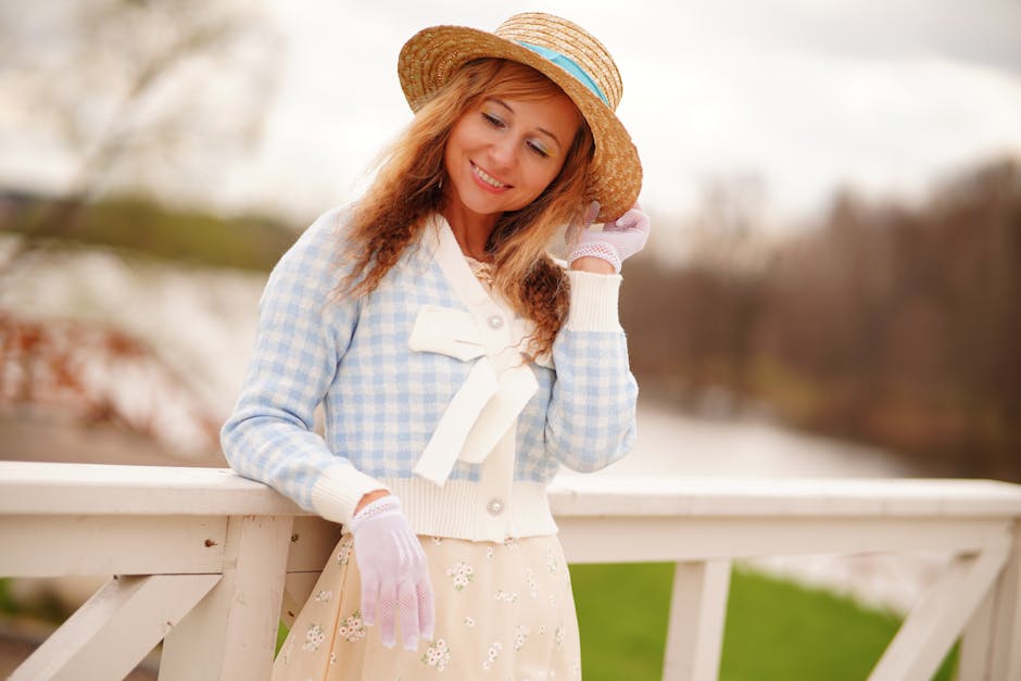 Woman in a sweater and hat posing outdoors on a balustrade. Elegant autumn fashion shot.