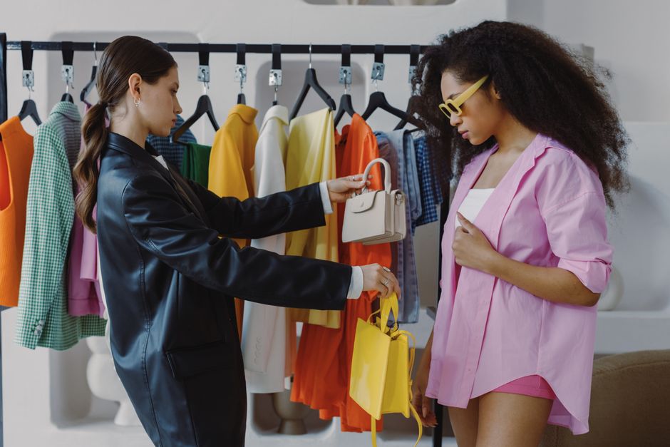 Two women shopping and exploring trendy fashion in a boutique setting.